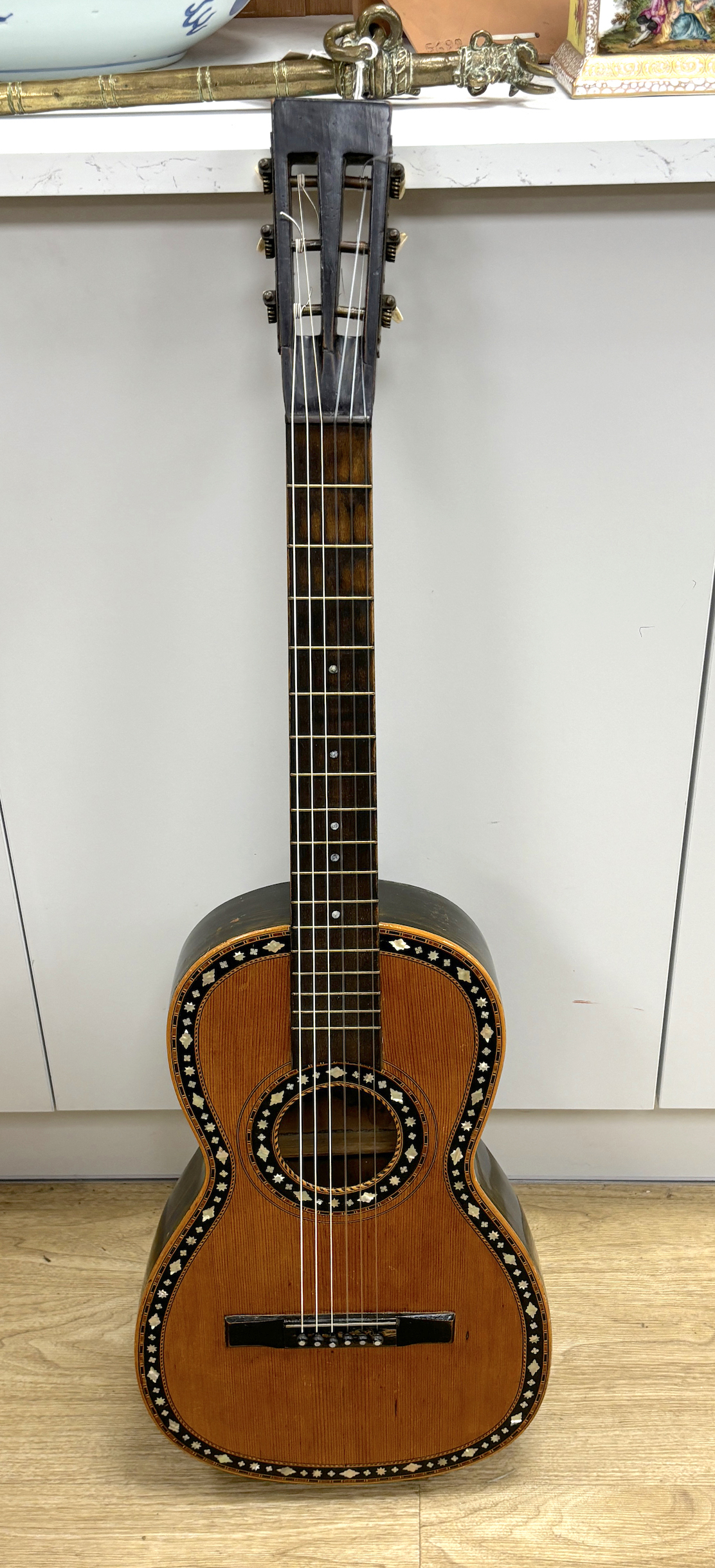 A mid-19th century Continental six string parlour guitar, soundboard inlaid with mother of pearl, rosewood back, length of body 45.5cm, overall length 92cm